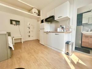 a kitchen with white cabinets and a sink at Studio aux portes de Paris in Gentilly
