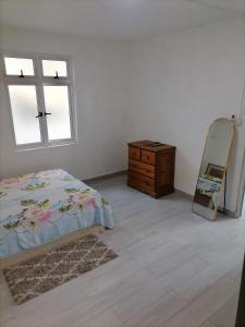 una camera da letto con un letto, un comò e uno specchio di Villa Orchidee a Trou aux Biches