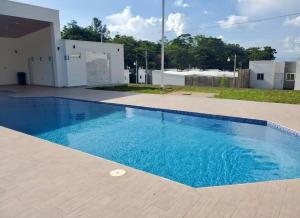 a large blue swimming pool in front of a building at Ahuachapan Tiny Rental Homes in Ahuachapán