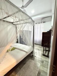a bed with mosquito netting in a room at Aloe villa in Weligama