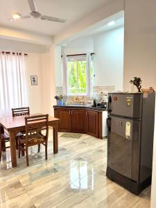 a kitchen and dining room with a table and a refrigerator at Aloe villa in Weligama