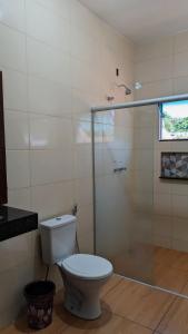 a bathroom with a toilet and a glass shower at Pousada Rancho Dona Lú Comfort in Pereira Barreto +9 photos
