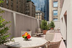 a table with a vase of flowers on a balcony at The Bayard in New York