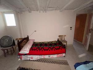 a bedroom with a bed and two chairs and a window at Aladdin inn نزل علاء الدين in Qasr Al Farafirah