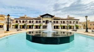 a fountain in the middle of a courtyard with a building at Casa Flamingolf Apartment in Fuente Alamo
