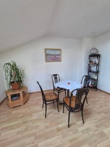 ein Esszimmer mit einem Tisch und vier Stühlen in der Unterkunft Charmanter Rückzugsort im DG in Lindenberg im Allgäu + 11 Fotos