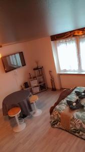 a bedroom with a bed and a table and two stools at Gîtes & Chambres d'hôtes Villa La Lorraine in Folkling