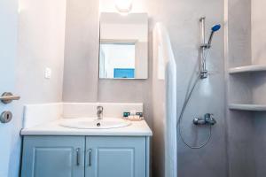 a bathroom with a sink and a mirror and a shower at Alas Residence Liotrivi Kythnos in Kithnos