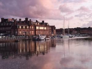 a group of boats docked in a harbor with buildings at Bramble Lodge in Blakeney