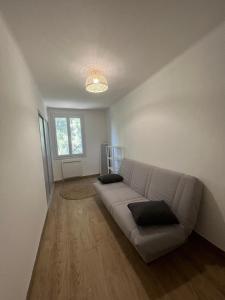 a white living room with a couch and a window at T3 au calme bien desservi à 10 minutes du Centre in Avignon