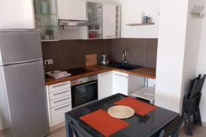 a small kitchen with a table and a refrigerator at T2 vue panoramique mer montagne in Cardo
