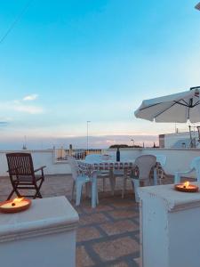 a patio with a table and chairs and an umbrella at Antica Dimora in Lizzano