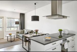 a kitchen and living room with a couch and a table at Holiday Club Vierumäki Apartments in Vierumäki