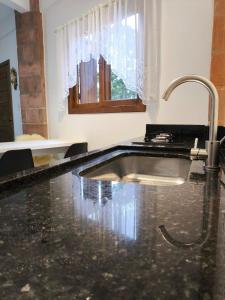 un bagno con un lavandino e un rubinetto di Casa Torta 01 a Gramado Altre 5 foto