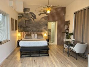 a bedroom with a bed and a table and a chair at Le Coucher de Soleil Spa in Bessens +41 photos