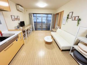 a living room with a white couch and a kitchen at 時旅ー大正 in Osaka
