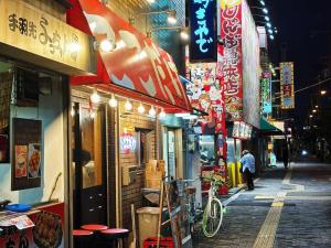 a city street with shops and a person walking down the street at 時旅ー大正 in Osaka