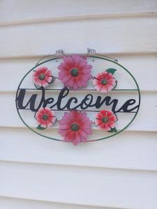 Un cartel de bienvenida en una casa con flores rosas. en Cozy Cool Ranch!, en Indianápolis