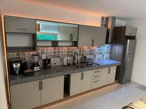 a kitchen with a sink and a refrigerator at Apartamento Luxo em Japaratinga in Japaratinga