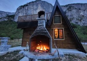 a fireplace in front of a house with a staircase at Komarnica Forest Owl 1 in Šavnik
