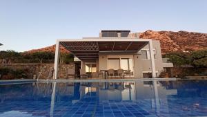 a villa with a swimming pool and a house at Luxurious Villa Tholos Crete in Thólos