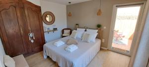 a bedroom with a bed with white sheets and a window at Le MAS CLEMENTINE in Puisserguier +40 photos
