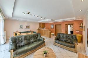 a living room with two leather couches and a table at Gästehaus Binz-Meyer Fewo Paulsberg in Lieser