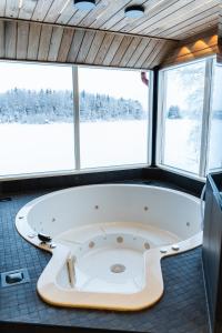a large bath tub in a room with windows at Private House by the River in Rovaniemi