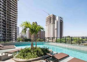 a swimming pool with a palm tree on top of a building at 505A - Rentaqui Studio Moema Stylo São Paulo in Sao Paulo