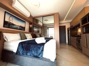 a bedroom with a large bed and a kitchen at 505A - Rentaqui Studio Moema Stylo São Paulo in Sao Paulo