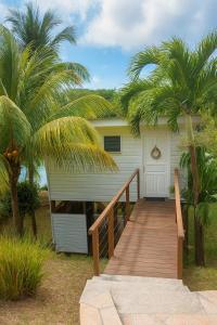 a house with a wooden walkway leading to a garage at Fisherman Hut in Le Gosier