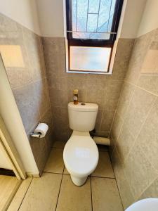 a bathroom with a toilet and a window at 3-Bedrooms Apartment in Bushmill Amorosa in Roodepoort
