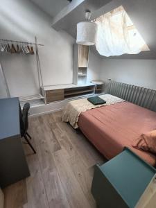 Un dormitorio con una cama con una colcha roja. en 'La forêt enchantée', en Villeurbanne