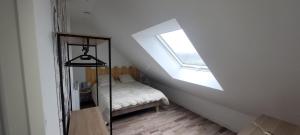 a attic room with a bed and a window at gîte de casson in Casson