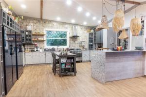 a large kitchen with white cabinets and a table at Villa Encanto Ecolodge in Calobre