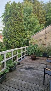 a wooden deck with a white fence and some plants at Family rooms in central, historic Gouda in Gouda