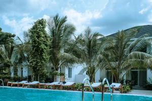 a pool at the resort with palm trees at Balungi Boutique Hotel in Uroa