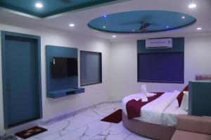 ein Schlafzimmer mit Bett und Flachbildfernseher in der Unterkunft Hotel Metro City in Gandhinagar