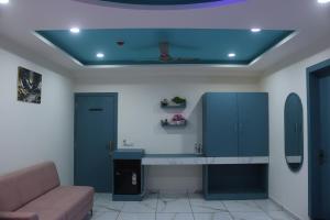 ein Wohnzimmer mit einem Schreibtisch und einem Sofa in der Unterkunft Hotel Metro City in Gandhinagar