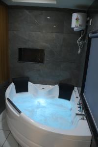 eine mit blauem Wasser gefüllte Badewanne in einem Badezimmer in der Unterkunft Hotel Metro City in Gandhinagar + 84 Fotos