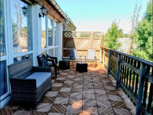 a screened porch with a couch and chairs on a balcony at Nähe Plohn Park - FEWO mit Spielzimmer und Balkon, DZ in Auerbach