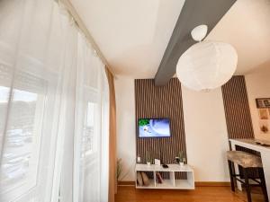 a living room with a large window and a television at Most apartman in Ruma