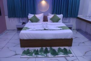 ein Schlafzimmer mit einem Bett mit Bäumen darauf in der Unterkunft Hotel Metro City in Gandhinagar