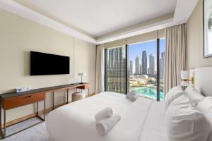 a hotel room with a bed and a tv at Address Residence Dubai Opera 25 by Luxstay Holiday Homes in Dubai +12 photos