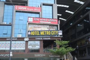 eine Hotelmekkastadt mit Schildern an einem Gebäude in der Unterkunft Hotel Metro City in Gandhinagar