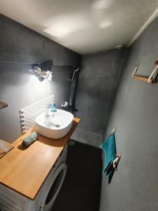 a bathroom with a white sink and a wooden counter at 'La forêt enchantée' in Villeurbanne +9 photos