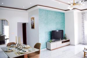 a living room with a table and a tv at Appartement Genève in Yaoundé