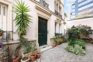 un edificio con una puerta verde y un montón de macetas en Boulogne Albert Khan, en Boulogne-Billancourt