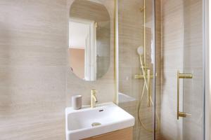 Un baño con un lavabo blanco y un espejo. en Boulogne Albert Khan, en Boulogne-Billancourt 3 fotos más