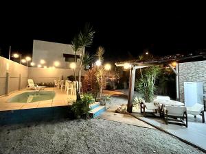a patio at night with a table and chairs at Casa de Vó in Porto Seguro